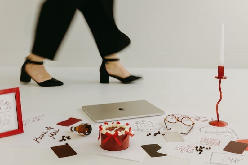 Creative workspace with laptop, branding materials, and designer in motion, representing DIY website vs hiring a designer.