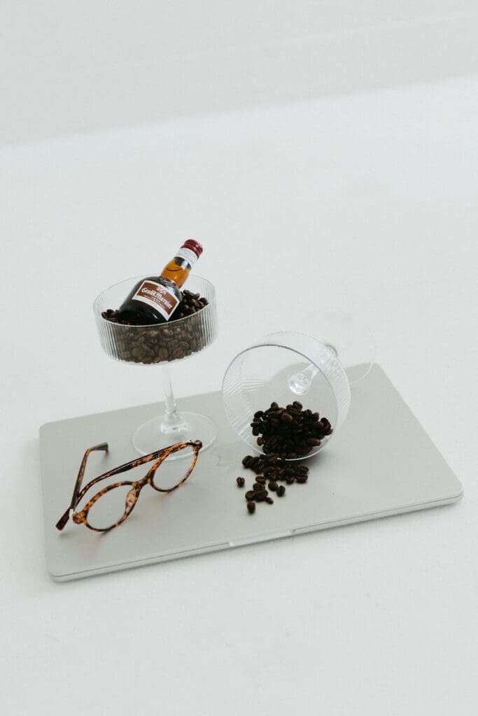 Minimal styled flat lay with coffee beans, glasses, and laptop, Showit vs Squarespace creative workspace visual
