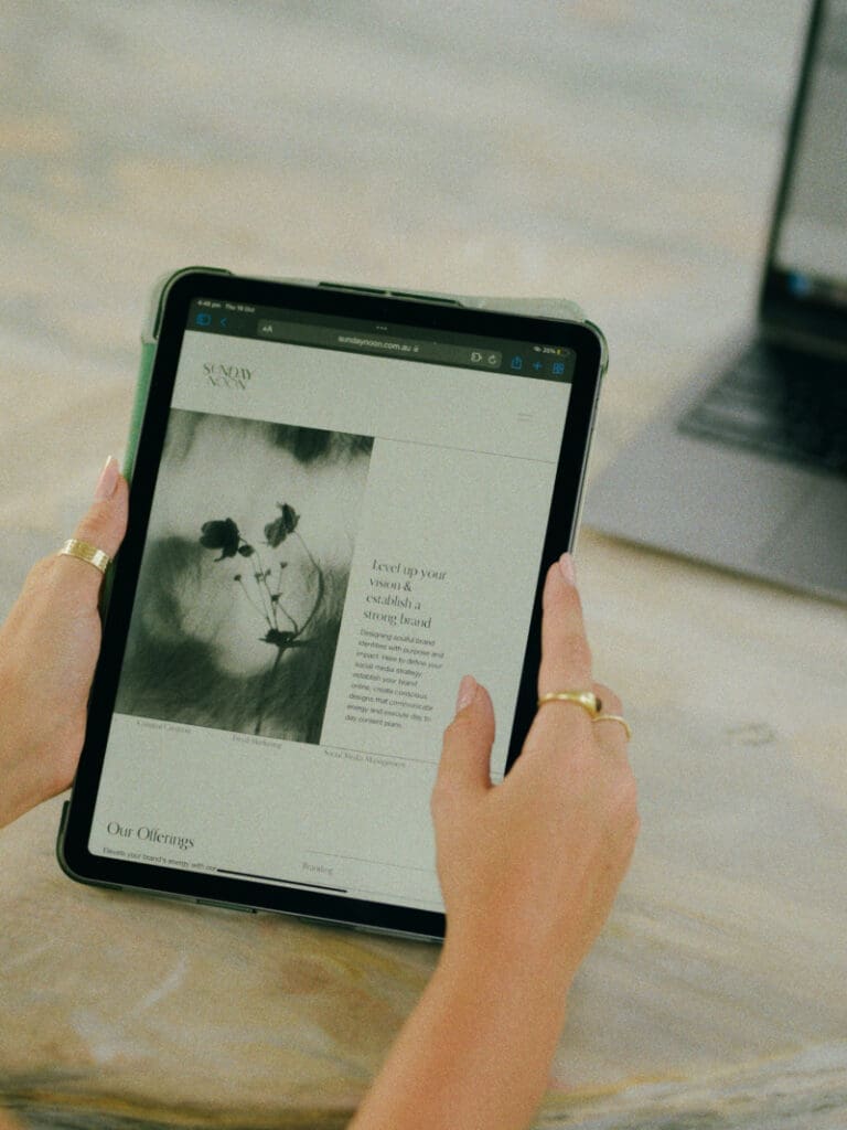 Hands holding tablet displaying clean website design, illustrating custom website vs template decision with minimal aesthetic