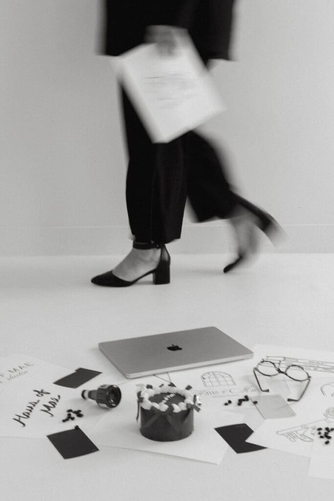 Blurred motion of person walking past laptop and creative tools on floor in minimal workspace