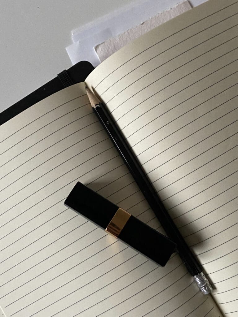 Website launch checklist planning with notebook, pencil, and minimal desk tools for content review