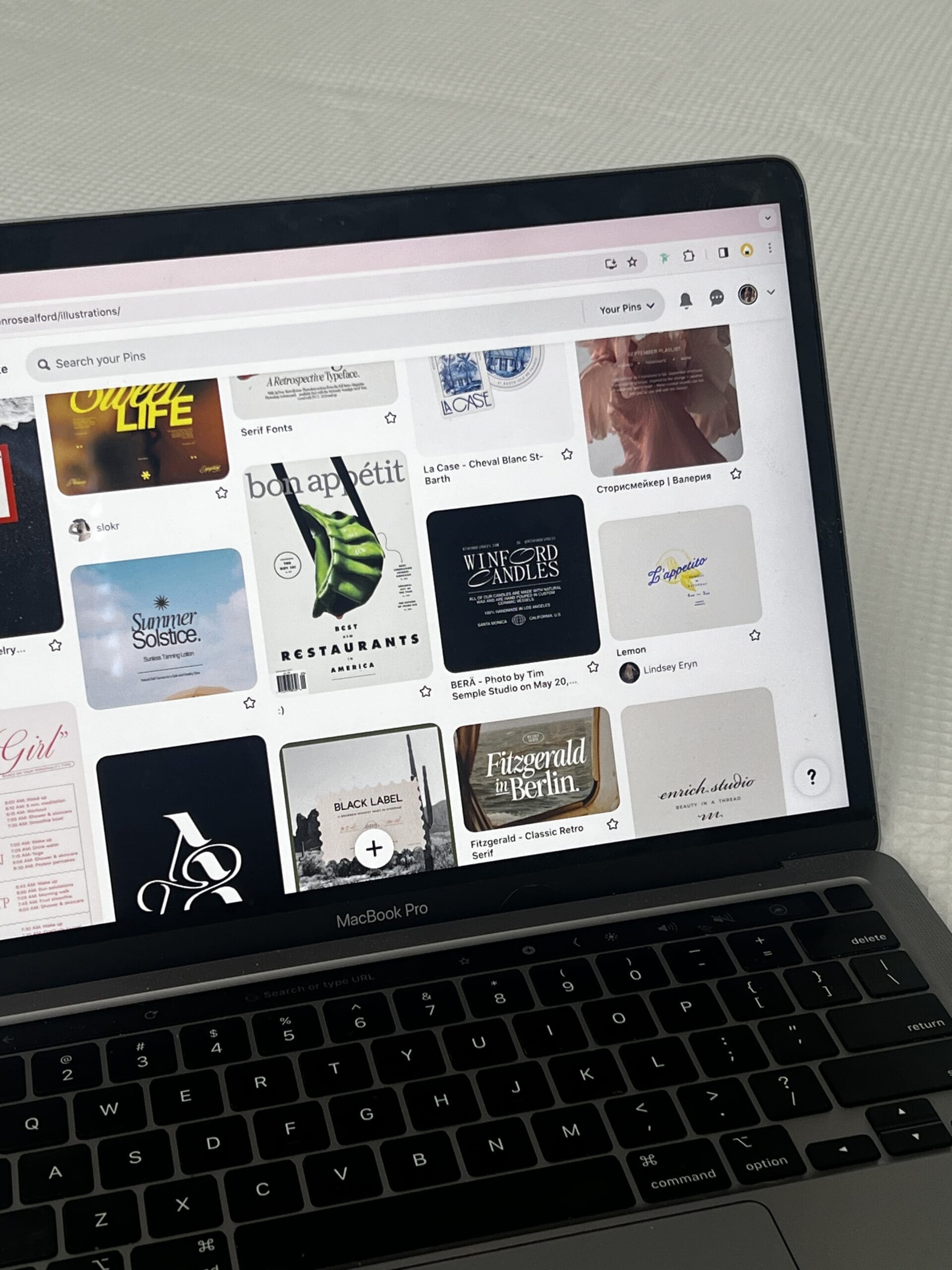 MacBook displaying Pinterest typography inspiration and font design examples while researching custom fonts for a Showit website.
